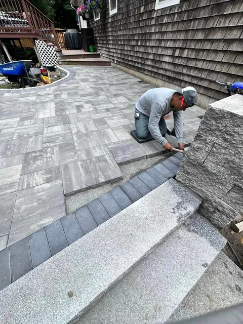 a man is kneeling down on a patio .