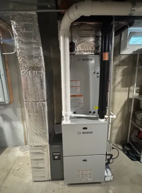 Bosch furnace in a basement setting with ductwork and piping.