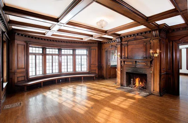 A large room with wood paneling and a fireplace.