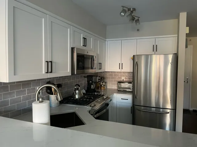 A kitchen with stainless steel appliances and white cabinets