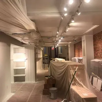 A room that is being painted with a mop and buckets.