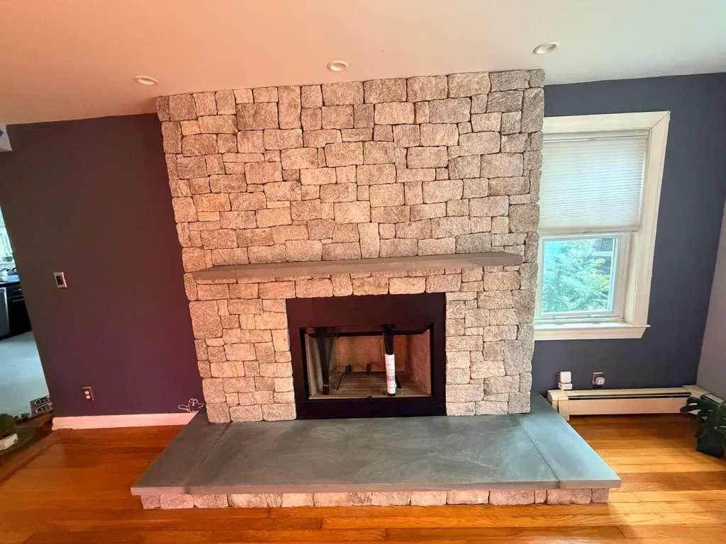 Finished interior natural stone fireplace with a bluestone hearth and mantel