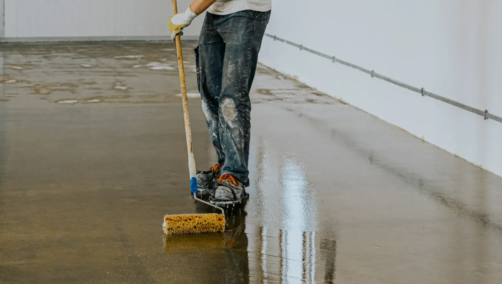 Epoxy expert rolling epoxy on garage floor