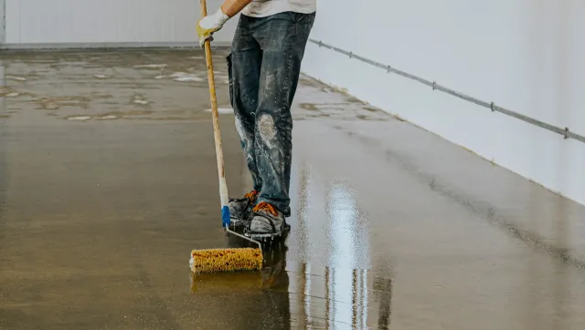 Epoxy expert rolling epoxy on garage floor