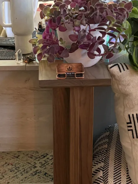 Solid walnut plant stand with a tapered fin-leg base, styled in a customer's living room