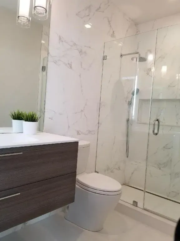 a bathroom with a toilet, sink and shower
