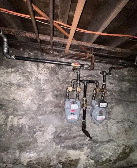 Vertical basement photo of water heaters and piping