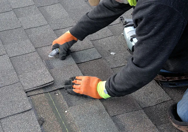 Worker repairing, damaged shingles.