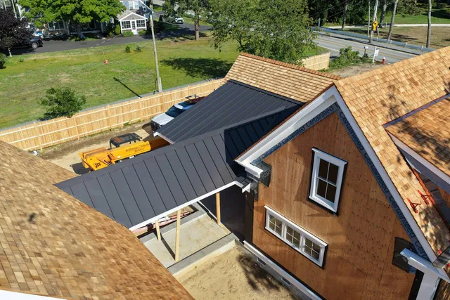 Cedar roof and standing seam metal roof with pond view in background