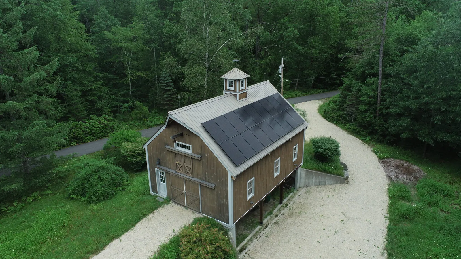 Drone view of solar panels on a rustic New Hampshire barn roof, a solar installation that could qualify for the 30% federal tax credit