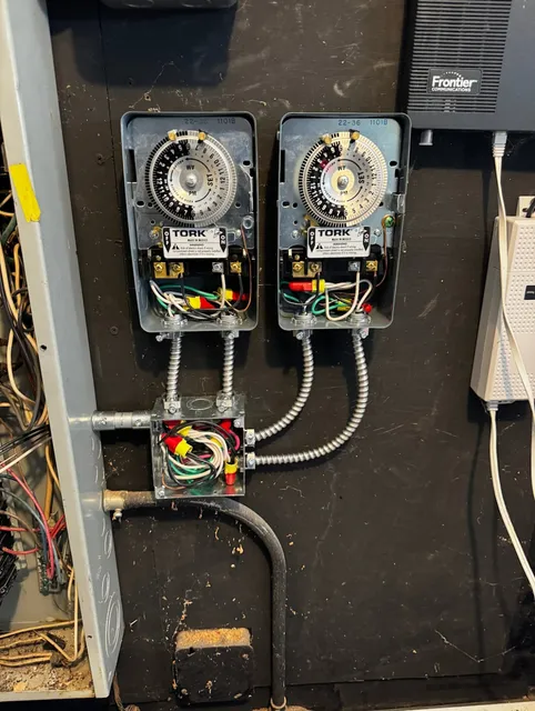 Electrical Timers and Wiring Inside a Circuit Panel with a Frontier Communications Device Nearby