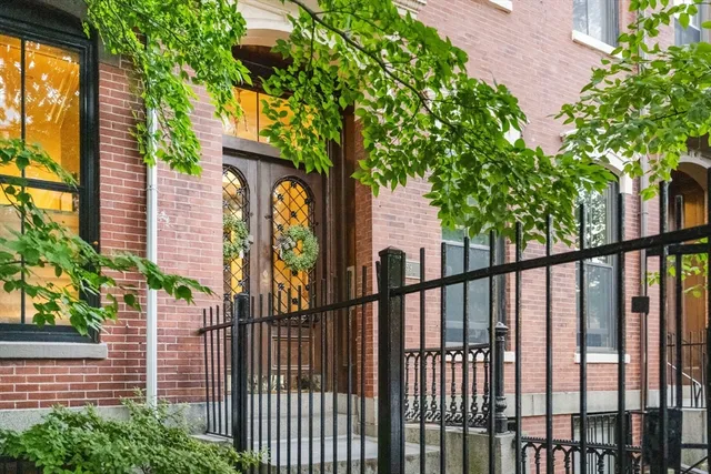 Penthouse perfection in Boston’s South End! This exceptional 2-bed, 2.5-bath residence blends historic character with modern luxury and offers a rare indoor/outdoor lifestyle in one of Boston’s most desirable neighborhoods. The entry level welcomes you with a spacious foyer, convenient laundry, and two oversized bedrooms, each featuring an en-suite bath and walk-in closet. Upstairs, the home opens into an impressive open-concept living and dining space with soaring 11’ ceilings, original pine floors, sleek built-ins, a gas fireplace, and a stylish powder room for guests. The chef’s kitchen is thoughtfully appointed with granite countertops, a gas range, stainless steel appliances, and oversized windows that fill the space with natural light. Just beyond the living area, step onto your private terrace—perfect for morning coffee, outdoor dining, or unwinding after a long day. Continue upstairs to the expansive 225-square-foot private rooftop oasis, where sweeping 360° city views create an incredible setting for entertaining, relaxing, and taking in the Boston skyline. Both outdoor spaces have been thoughtfully enhanced with custom landscaping by Winston’s Flowers, along with professionally installed Wi-Fi-enabled lighting and irrigation systems. Recent upgrades include a new HVAC system and hot water heater, providing added comfort and peace of mind. With its combination of historic South End charm, modern updates, generous living spaces, and truly exceptional private outdoor space, this is a rare penthouse offering with unbeatable views and style to match!