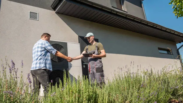 HVAC technician shaking hands with satisfied homeowner