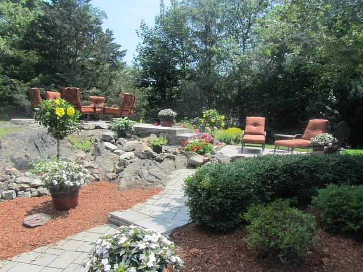 Paver patio and stone retaining wall with planted beds