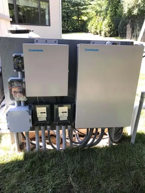 A electrical box is sitting on top of a lush green field.