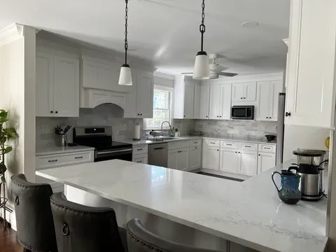 white kitchen renovation with island, quartz countertops, and pendant lights in Trumbull CT