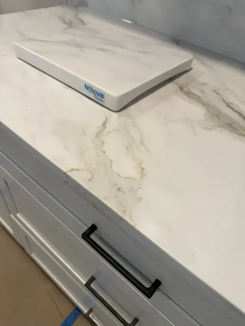 White marble-look countertop with a small white box on top and a cabinet drawer below