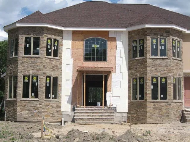 A large house with a lot of windows is under construction