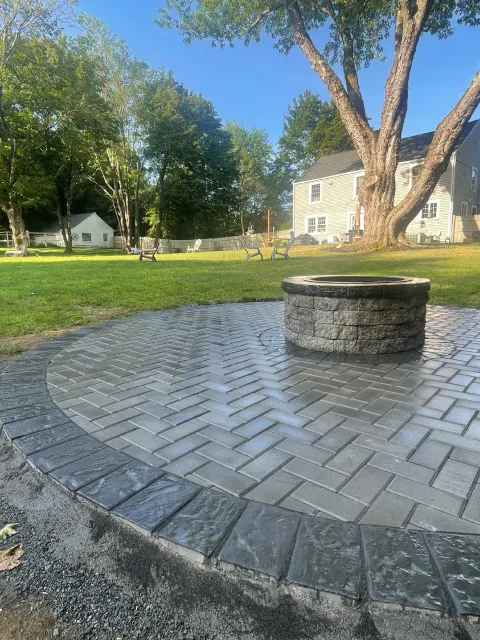 The Englishmen Masonry built this round patio with herringbone pattern and a fire pit for a home in North Hampton, NH