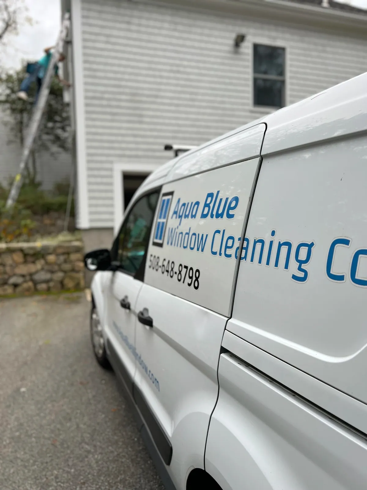Aqua Blue Window van with worker on ladder