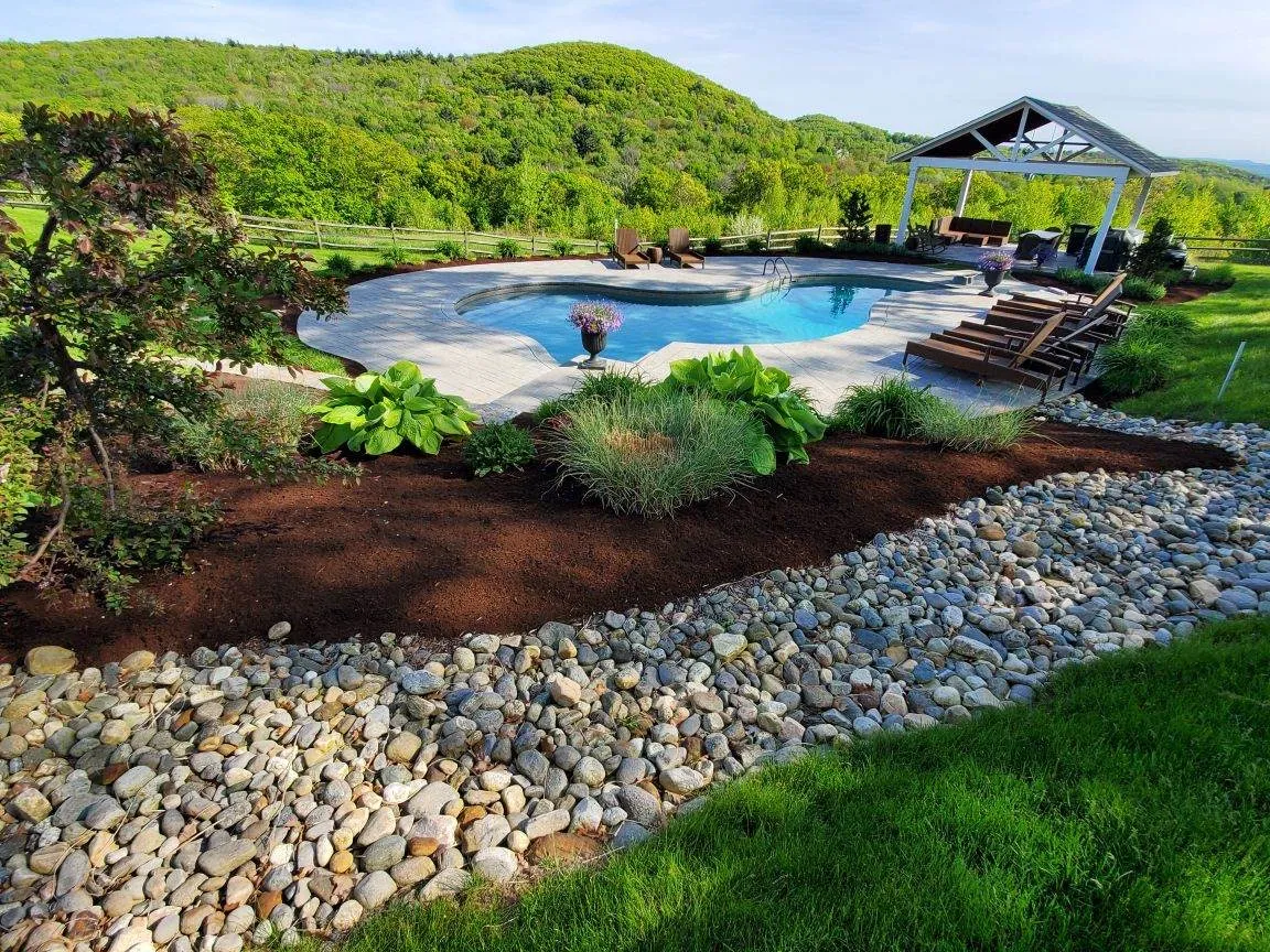 Pool transformation after landscaping services, fresh mulch, stone and plants