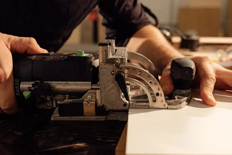 Festool domino tool close up for loose mortise and tenon joinery on plywood, hardwood, furniture, and cabinetry.