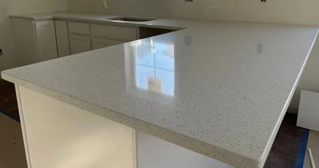 A kitchen with white cabinets and a white counter top.