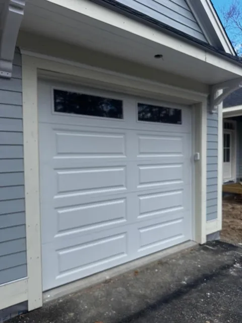 Bluefin single white garage door on gray house exterior