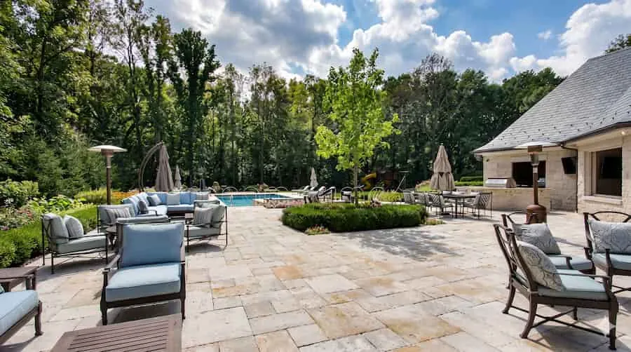 Premium backyard stone patio with pool and outdoor seating area