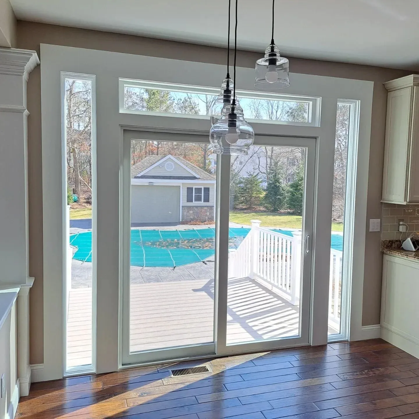 Patio door install with sidelights and a new deck built in Plymouth MA by Freeland Woodworks.