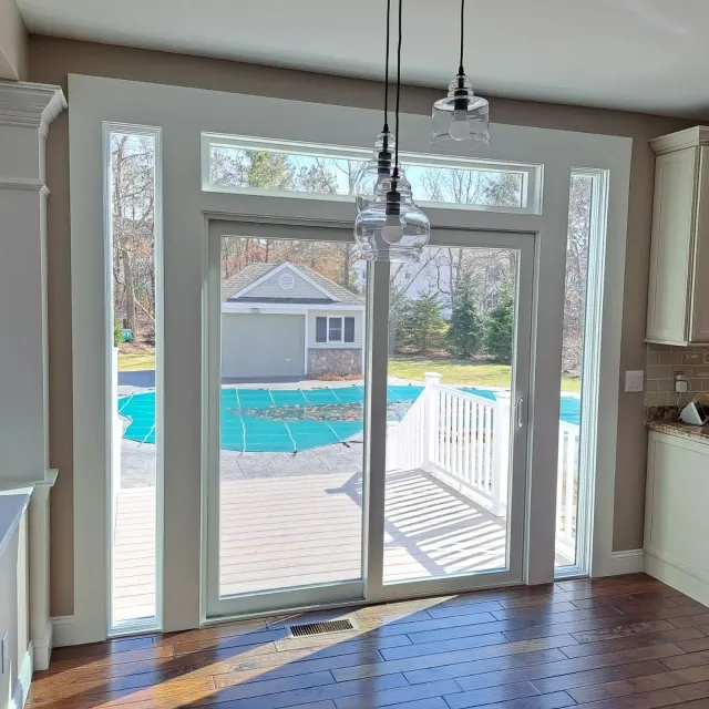 Patio door install with sidelights and a new deck built in Plymouth MA by Freeland Woodworks.