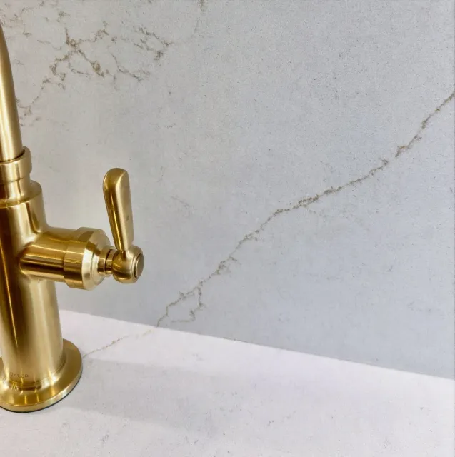 One continuous canvas.

From kitchen countertops straight up the full-height backsplash, aligning the veins reads as a single composition. 

This Valor Gold quartz features a soft white base with golden veins and a lava finish that enhances its natur