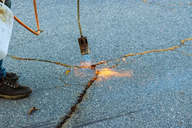 Filled driveway cracks before sealcoating in Massachusetts