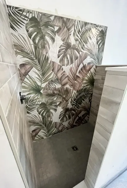 Bathroom with a botanical print feature wall and textured subway tile