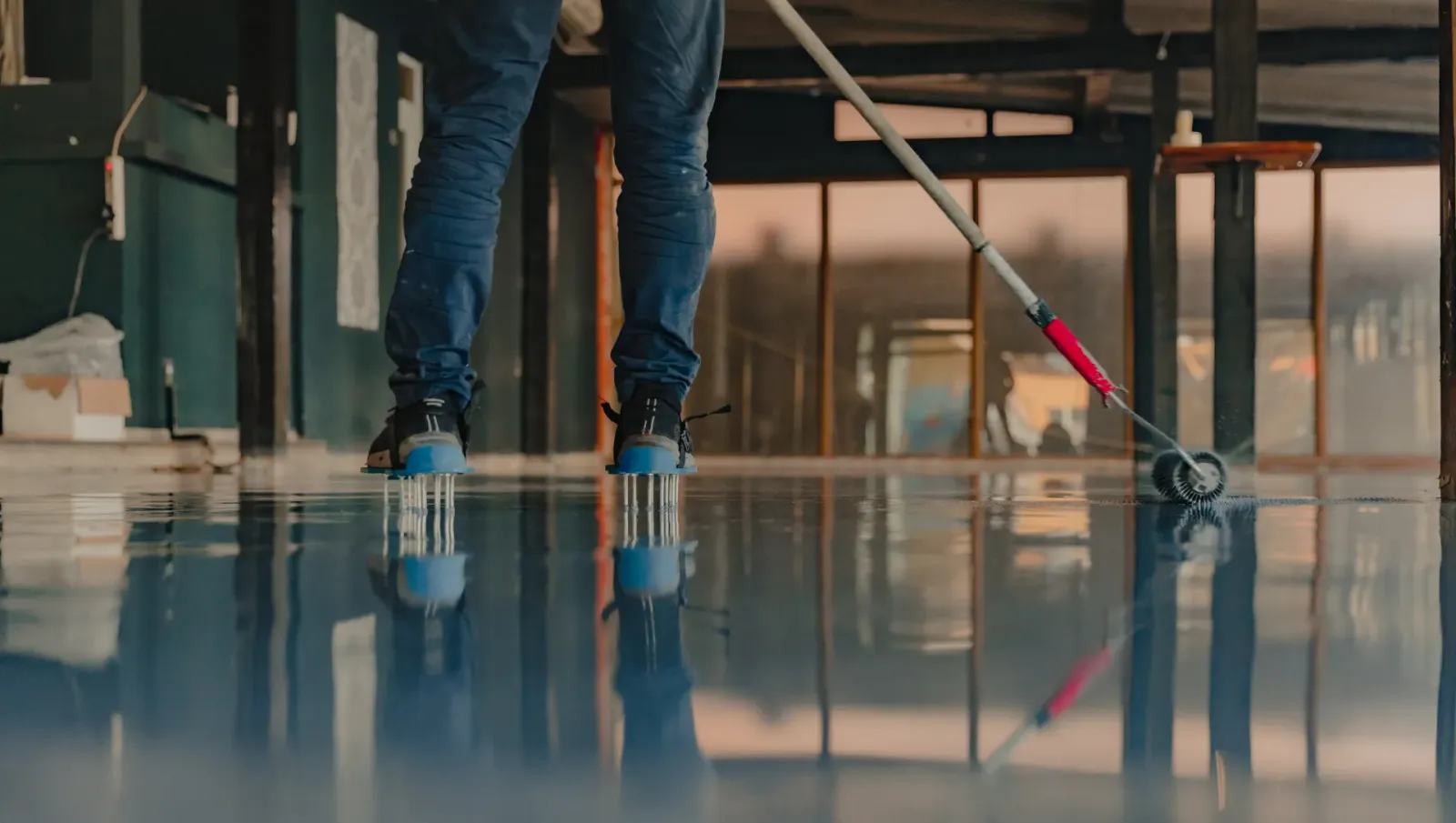 Crew member rolling epoxy on warehouse floor