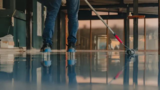 Crew member rolling epoxy on warehouse floor