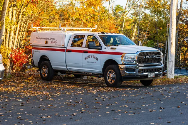 An aerial view of a colby & gale fuel truck navigating a fall foliage colorful road.