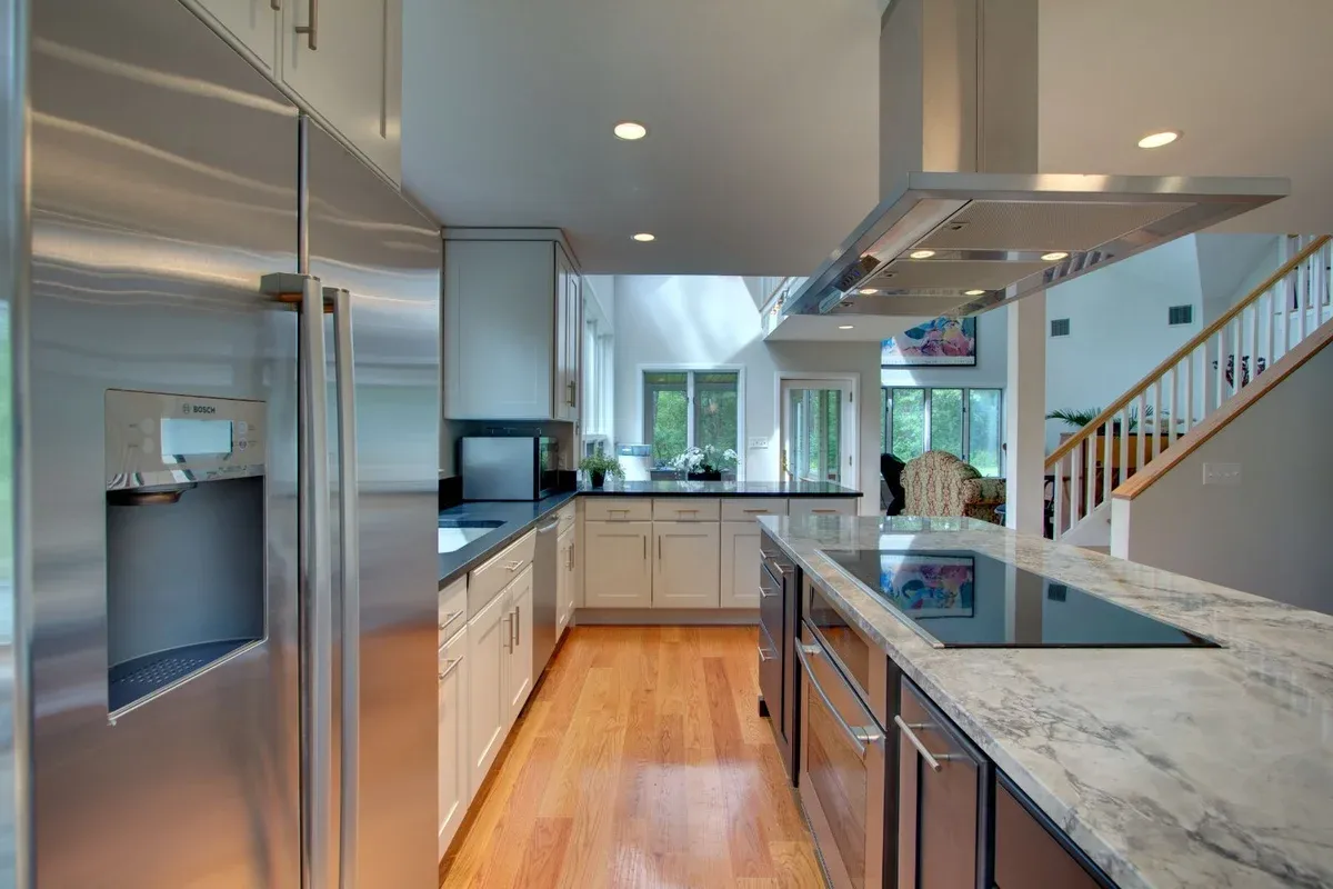 Open-concept kitchen featuring large island and stainless appliances in North Shore MA by PEGASUS Design-to-Build-optimized