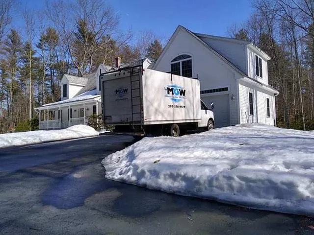 White seamless gutter system installed on a Maine house