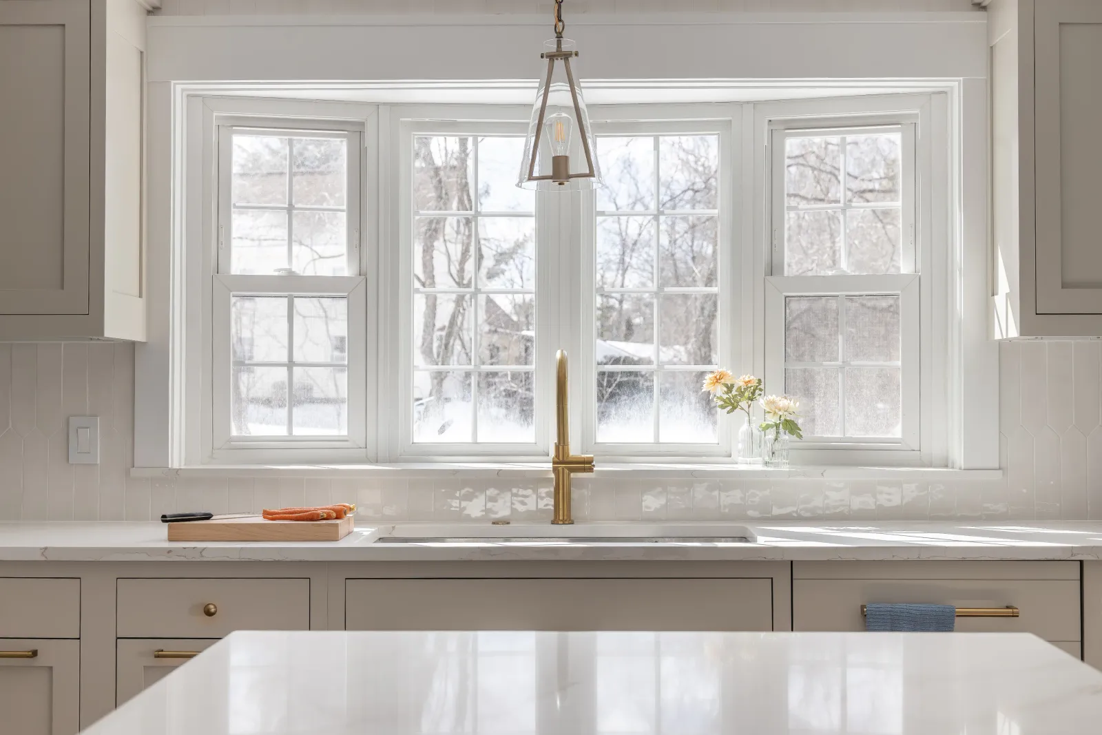 Kitchen with painted cabinetry and bay window