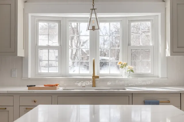 Kitchen with painted cabinetry and bay window