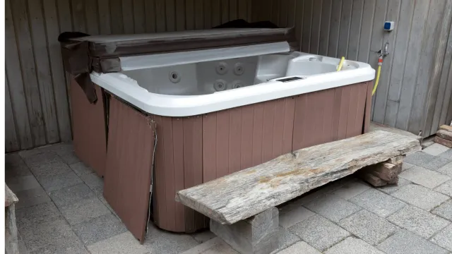 EZ-Haulin' team safely dismantling and loading a hot tub onto a truck for eco-friendly disposal or recycling.