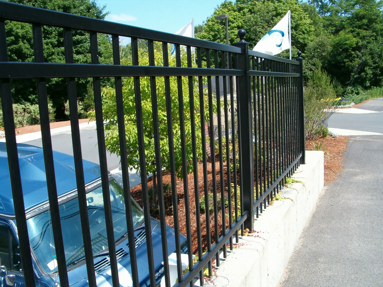 Black ornamental fence along a roadside wall