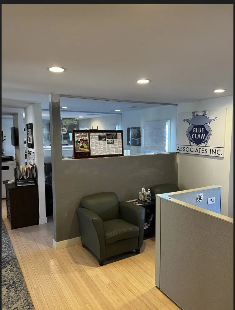 The Blue Claw Associates office lobby — green leather chair, the BCA crab logo on the wall, and Lawn & Landscape Top 100 magazine framed beside it