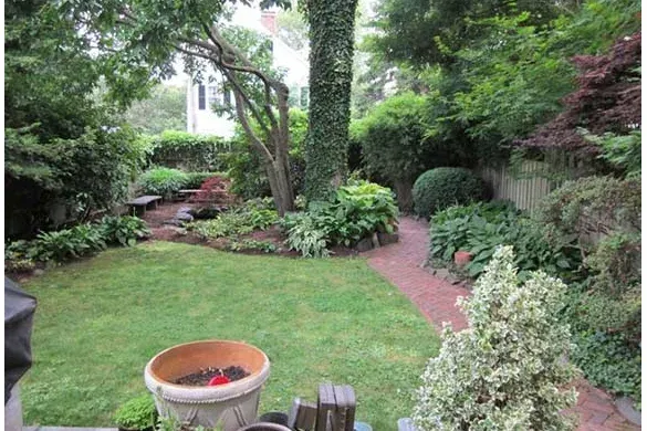 Small city backyard with brick path and shade borders