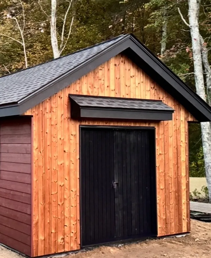 Outbuilding finished with cedar siding and black trim