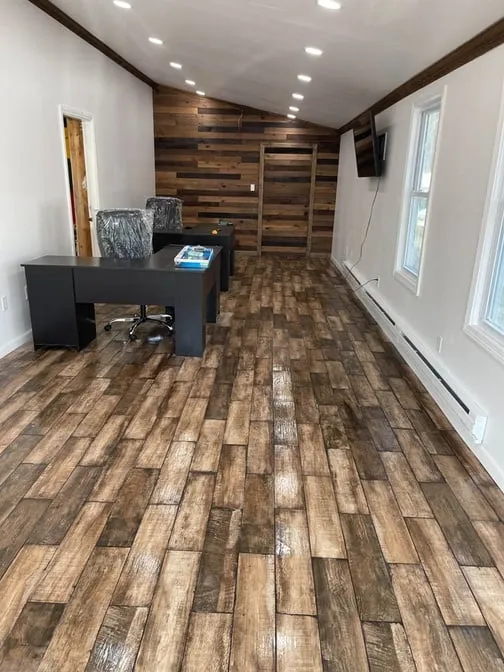 a home office with wood paneling and a desk