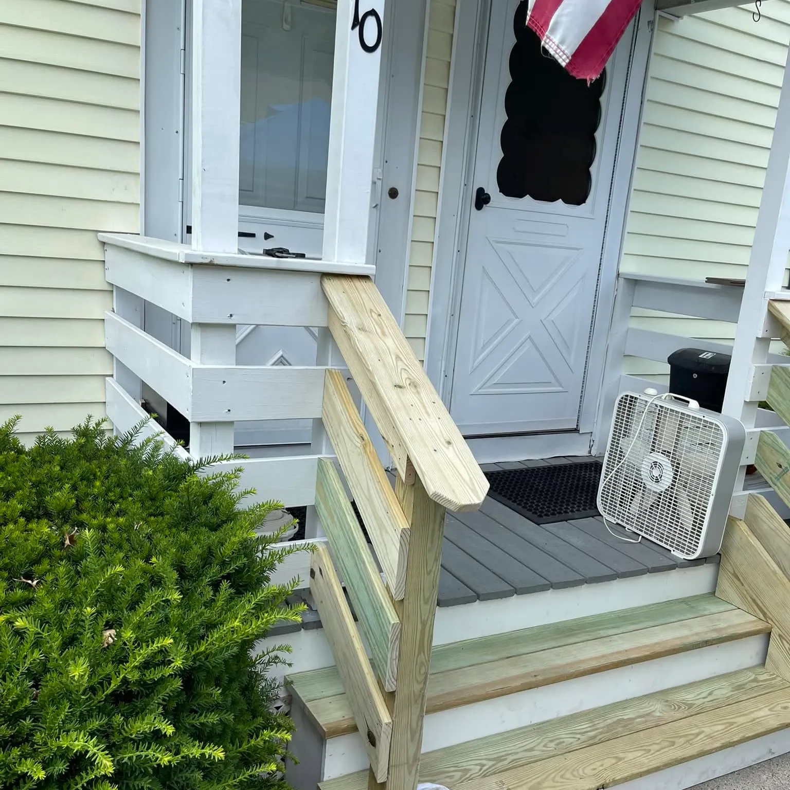 Rebuilt front steps and handrail at a porch entry