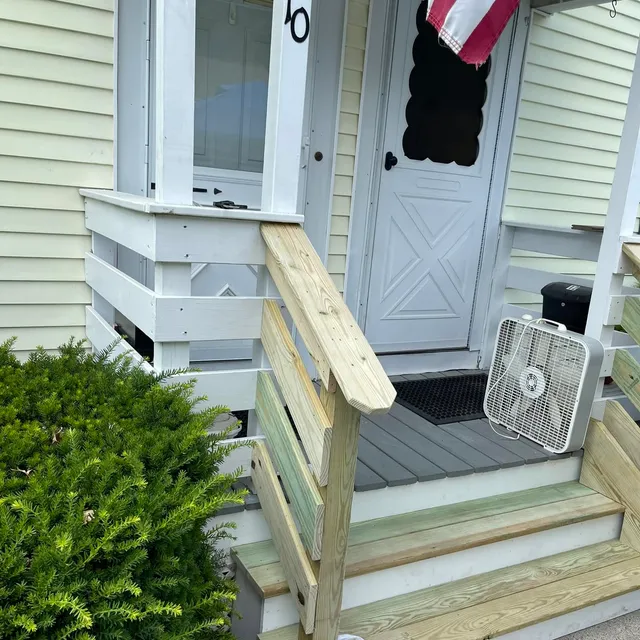 Rebuilt front steps and handrail at a porch entry