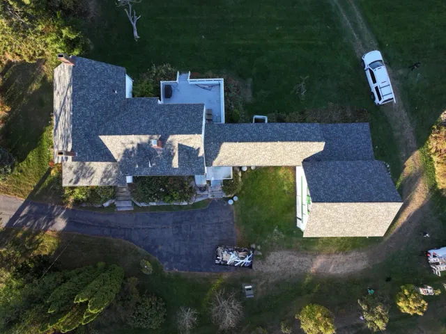 Aerial view of a house with a gray roof and driveway